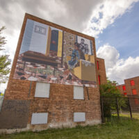 A large banner covers the side of a boarded up brick building