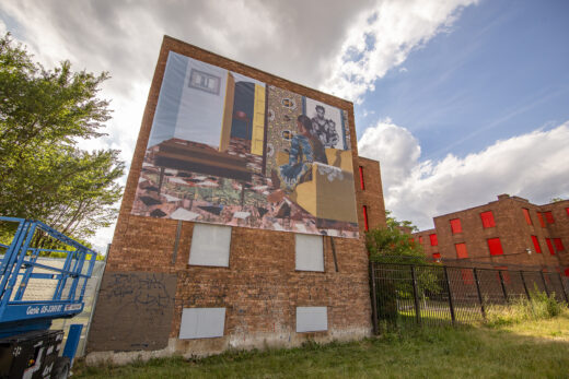 A large banner covers the side of a boarded up brick building