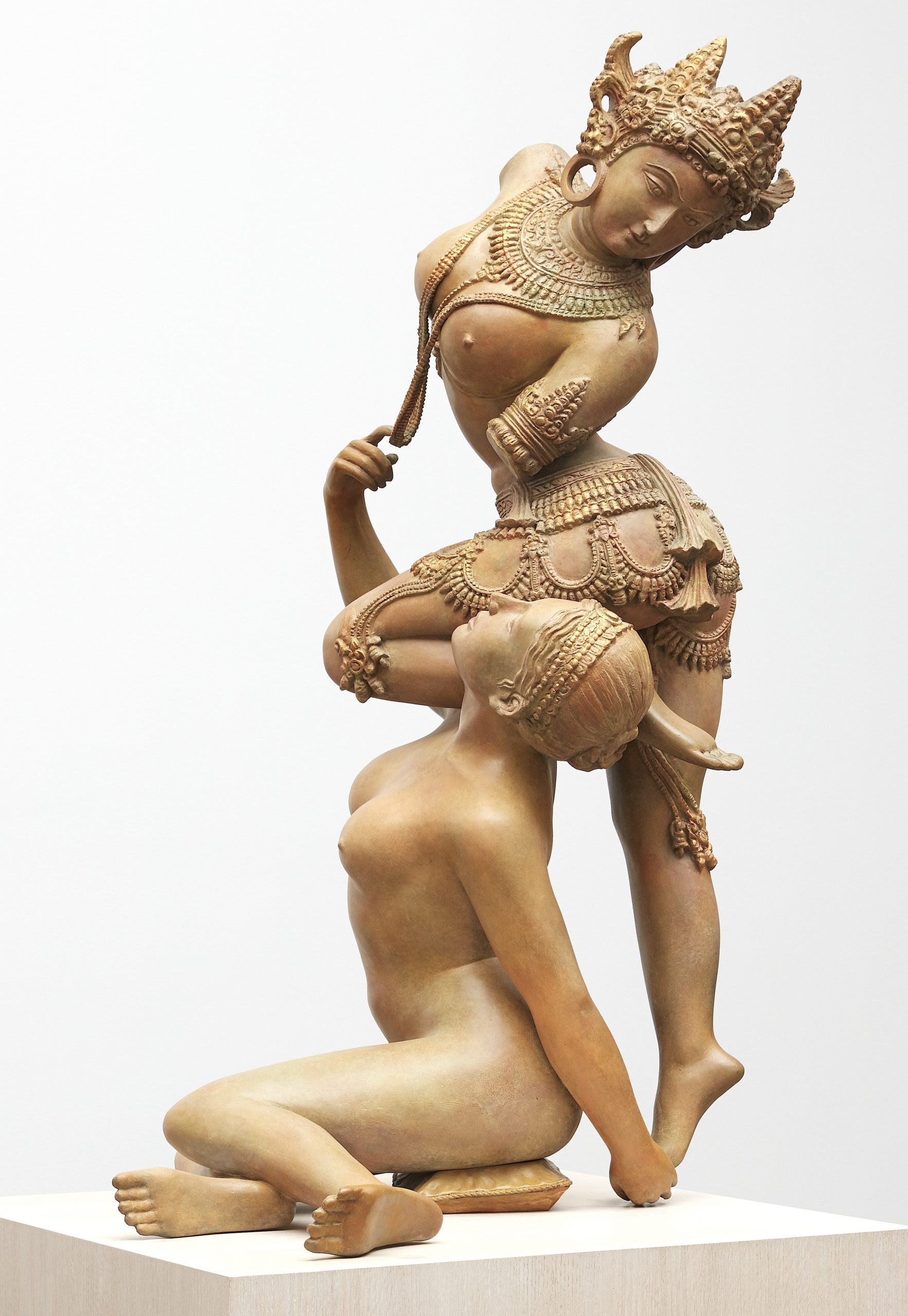 A heavily patinated bronze sculpture depicting two intertwined female figures