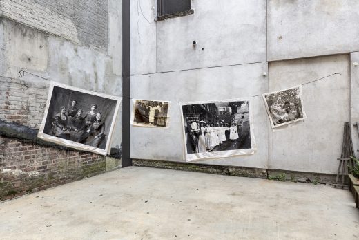 Four photographs of women printed on linen hang on a clothesline in an empty lot