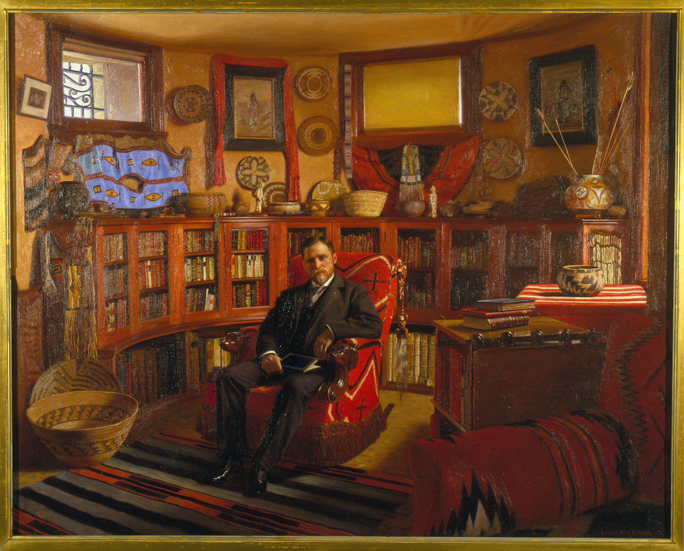 A painted portrait of a man seated in a study filled with books and Native American artifacts.