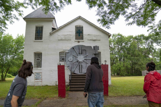 A metal bank vault hangs over the doorway of a church