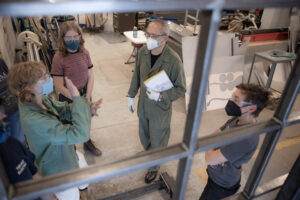 Four people in conversation in a metal fabrication studio