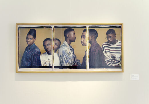 Gallery installation featuring a three-panel photograph of students.